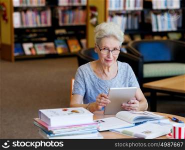 Elderly lady working with tablet. Learning new technologies