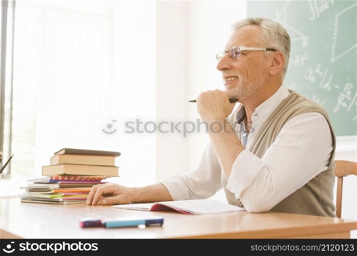 elderly lecturer sitting desk auditorium