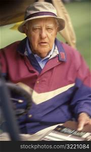 Elderly Male Golfer Driving Golf Cart