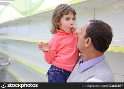 elderly man at empty shelves in shop with child on hands