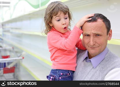 elderly man at empty shelves in shop with child on hands, grand daughter feels sorry for grandfather