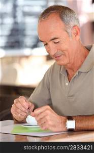 Elderly man drinking a cup of coffee