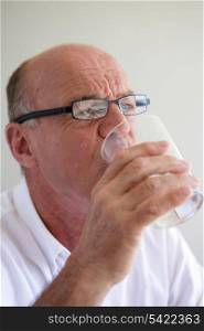 Elderly man drinking a glass of water