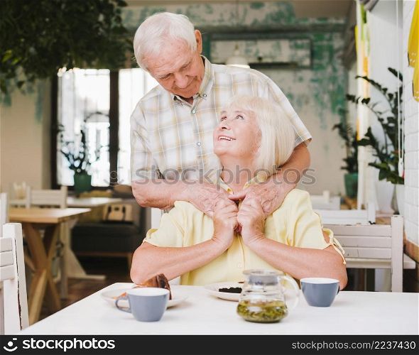 elderly man embracing wife from