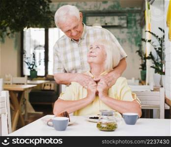 elderly man embracing wife from