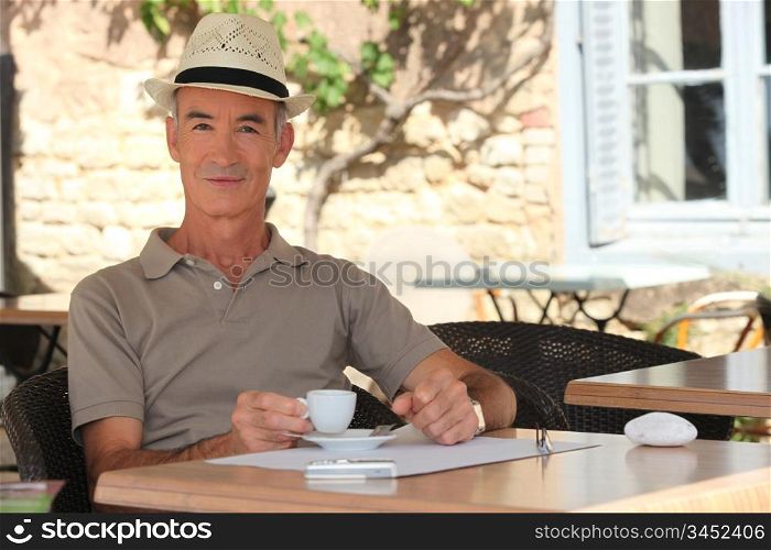 Elderly man enjoying a cup of coffee in a cafe