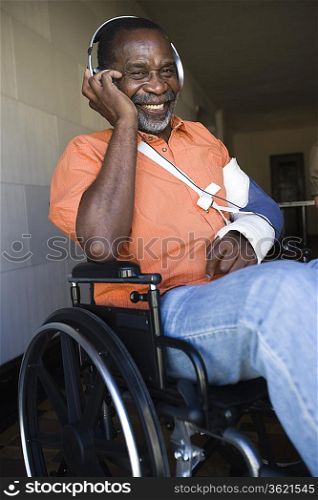 Elderly man in wheelchair listening to music