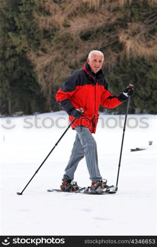 elderly man in winter on snowshoes