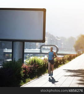 Elderly man jogging down the promenade