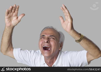 Elderly man laughing over colored background