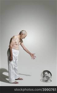 Elderly man looking at a globe