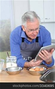 Elderly man looking at recipe on electronic tab