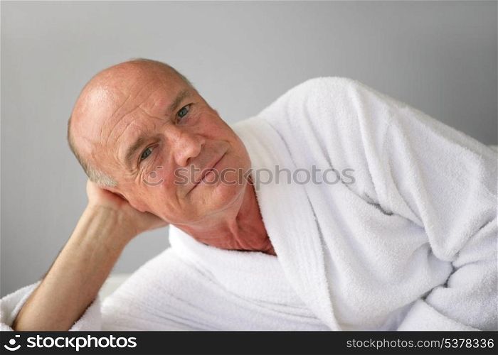 Elderly man lying in his bathrobe