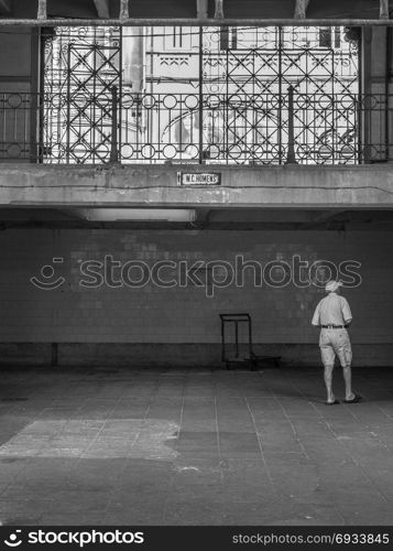 Elderly Man near Restroom Entrance in Bolhao Market, Porto - Portugal