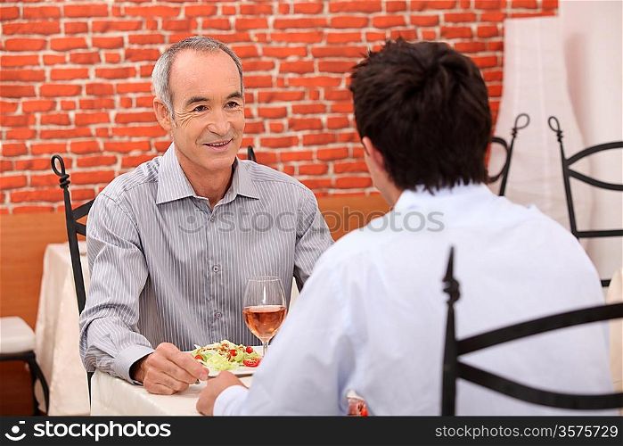 Elderly man out with his grandson for a meal