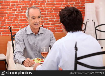 Elderly man out with his grandson for a meal