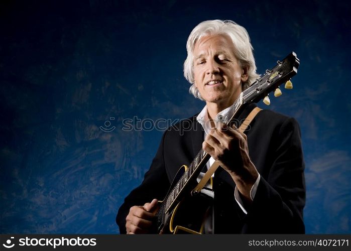 Elderly man playing the guitar