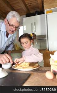 Elderly man preparing breakfast for granddaughter
