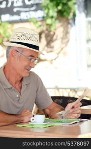 Elderly man sat drinking coffee on terrace