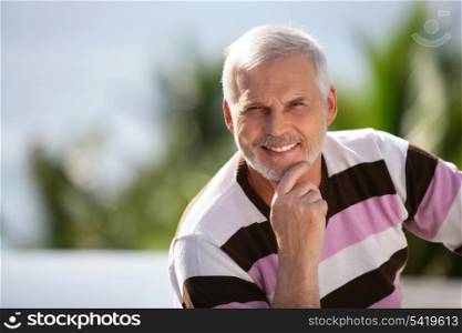 Elderly man sitting in garden
