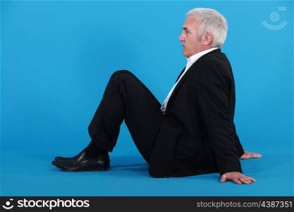 Elderly man sitting on the floor