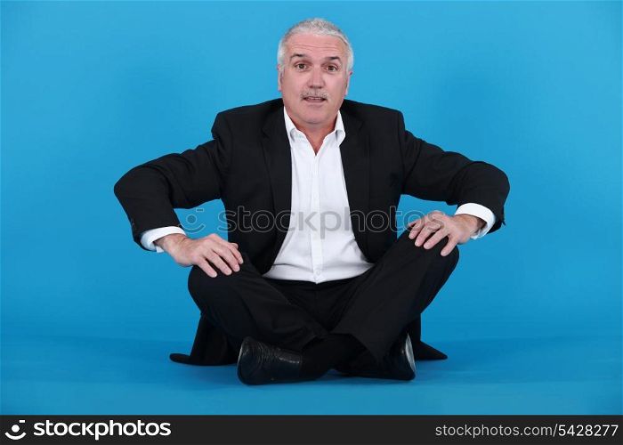 Elderly man sitting on the floor