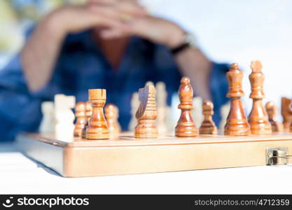 Elderly man sitting outdoors with chess. Thinking chess strategy