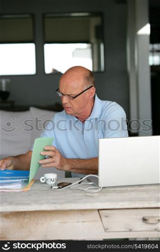 Elderly man sorting through his paperwork