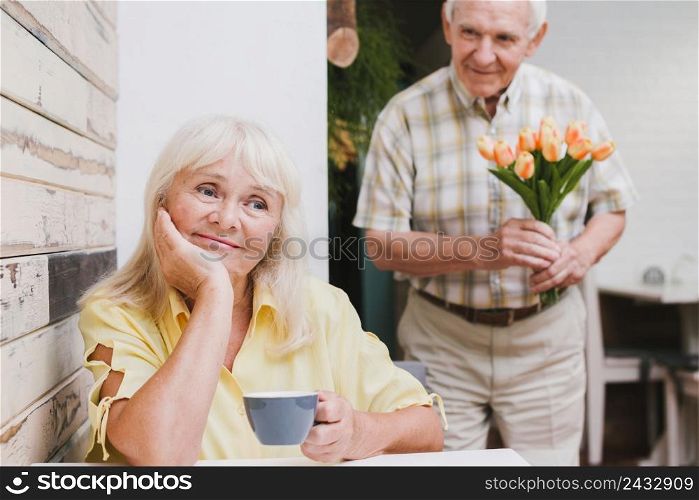 elderly man standing beloved with flowers