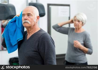 elderly man wiping his hair with blue towel
