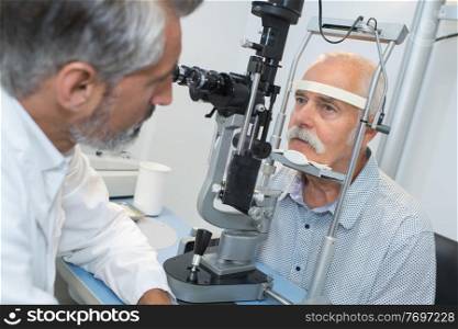 elderly man with glaucoma at the optician for optical examination