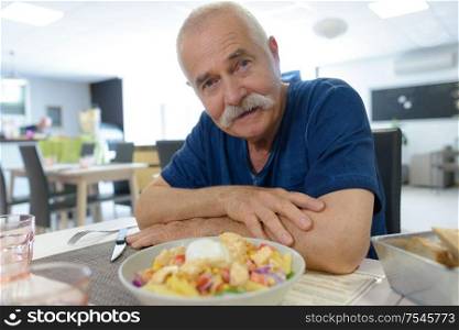 elderly man with his order in a restaurant