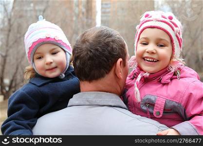 elderly man with two children on hands from back, focus on senior