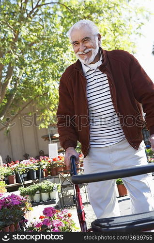 Elderly man with walking frame in garden center