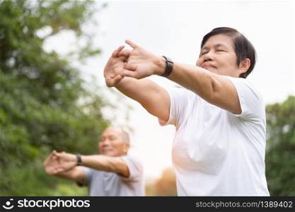 Elderly people stretching hands, arms before exercise at park. Happy Asian Senior couple enjoy workout at outdoor in the morning. Old man and woman relaxing and breathing in fresh air. Good Health, Wellness.
