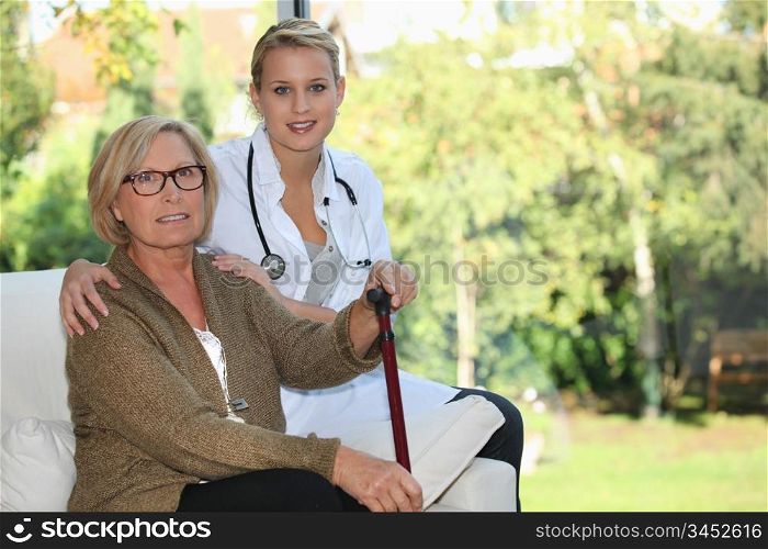 Elderly woman and young female caregiver at home
