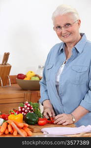 Elderly woman chopping vegetables