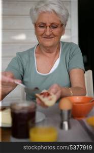 Elderly woman eating balanced breakfast