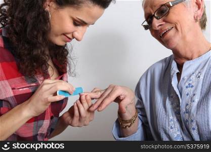 Elderly woman having a manicure