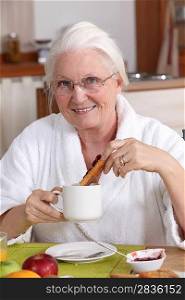 Elderly woman having breakfast