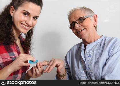 Elderly woman having manicure