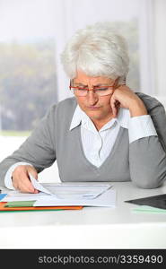 Elderly woman having trouble filling in paperwork