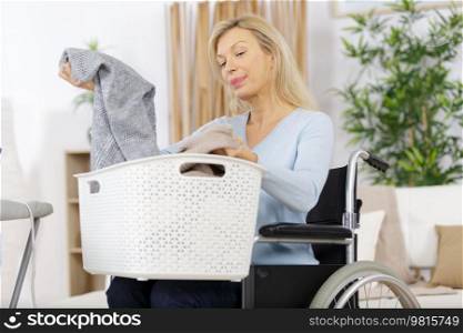 elderly woman holding a laundry basket filled with clothes