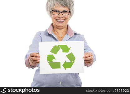 Elderly woman holding a paper card with the recycling sign