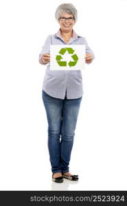 Elderly woman holding a paper card with the recycling sign