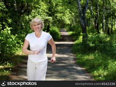 Elderly woman likes to run in the park. Healthy lifestyle
