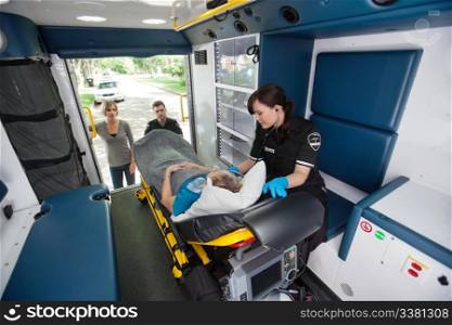 Elderly woman loaded in ambulance being given oxygen