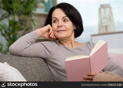 elderly woman reading a book on relaxing day