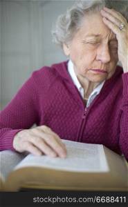 Elderly woman reading and meditating