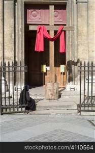 Elderly woman sits outside church, Paris, St Germain